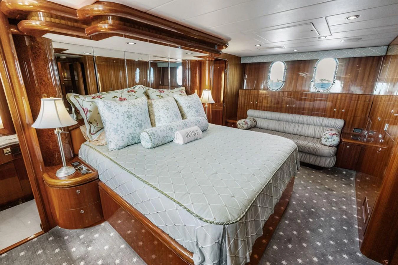 The master stateroom features a luxurious bed with elegant bedding and ample natural light. aboard BABE Yacht for Sale