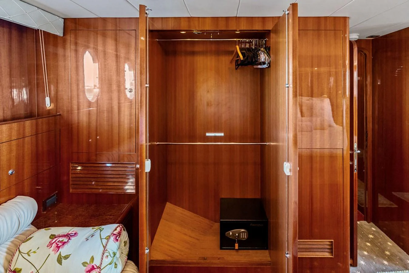The image showcases a wooden wardrobe with a safe inside, highlighting the yacht's storage amenities. aboard BABE Yacht for Sale