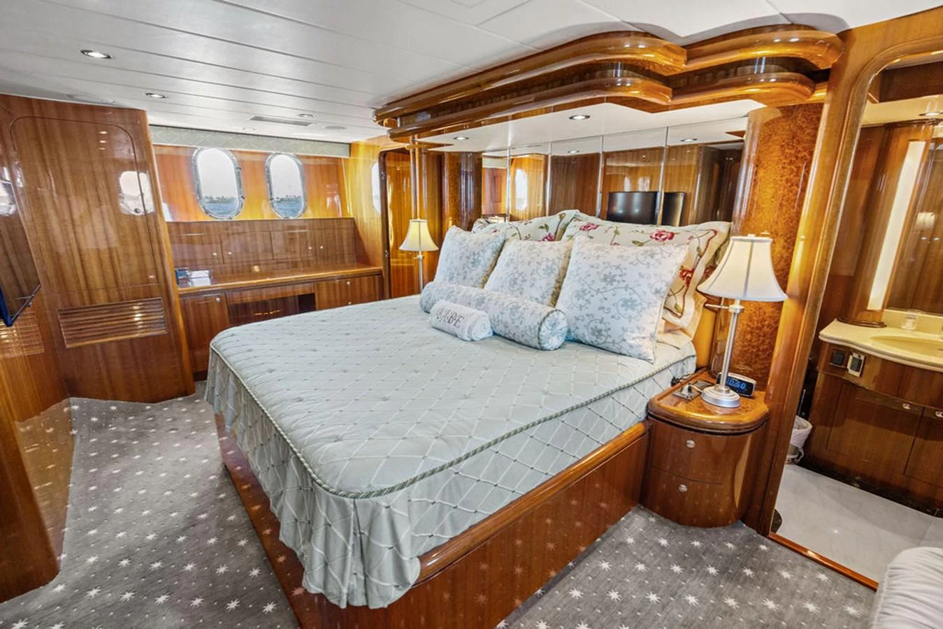 The master stateroom features a luxurious bed with elegant bedding and warm wood accents. aboard BABE Yacht for Sale