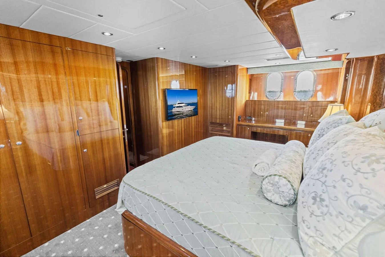 The stateroom features luxurious wood paneling, a plush bed, and modern amenities for ultimate comfort. aboard BABE Yacht for Sale