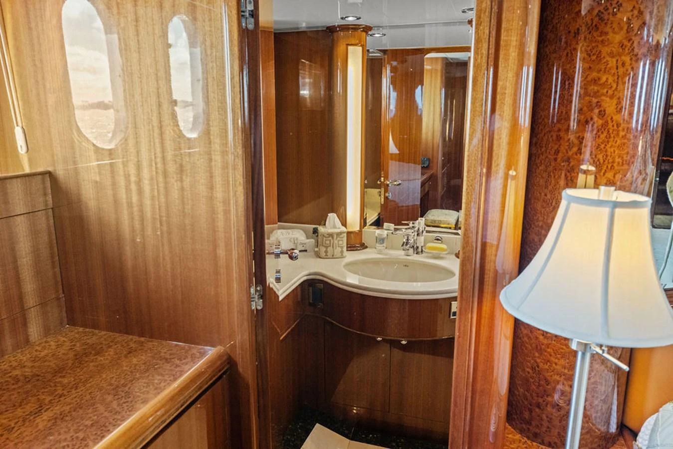 The yacht's bathroom features elegant wood paneling and a well-lit vanity area. aboard BABE Yacht for Sale