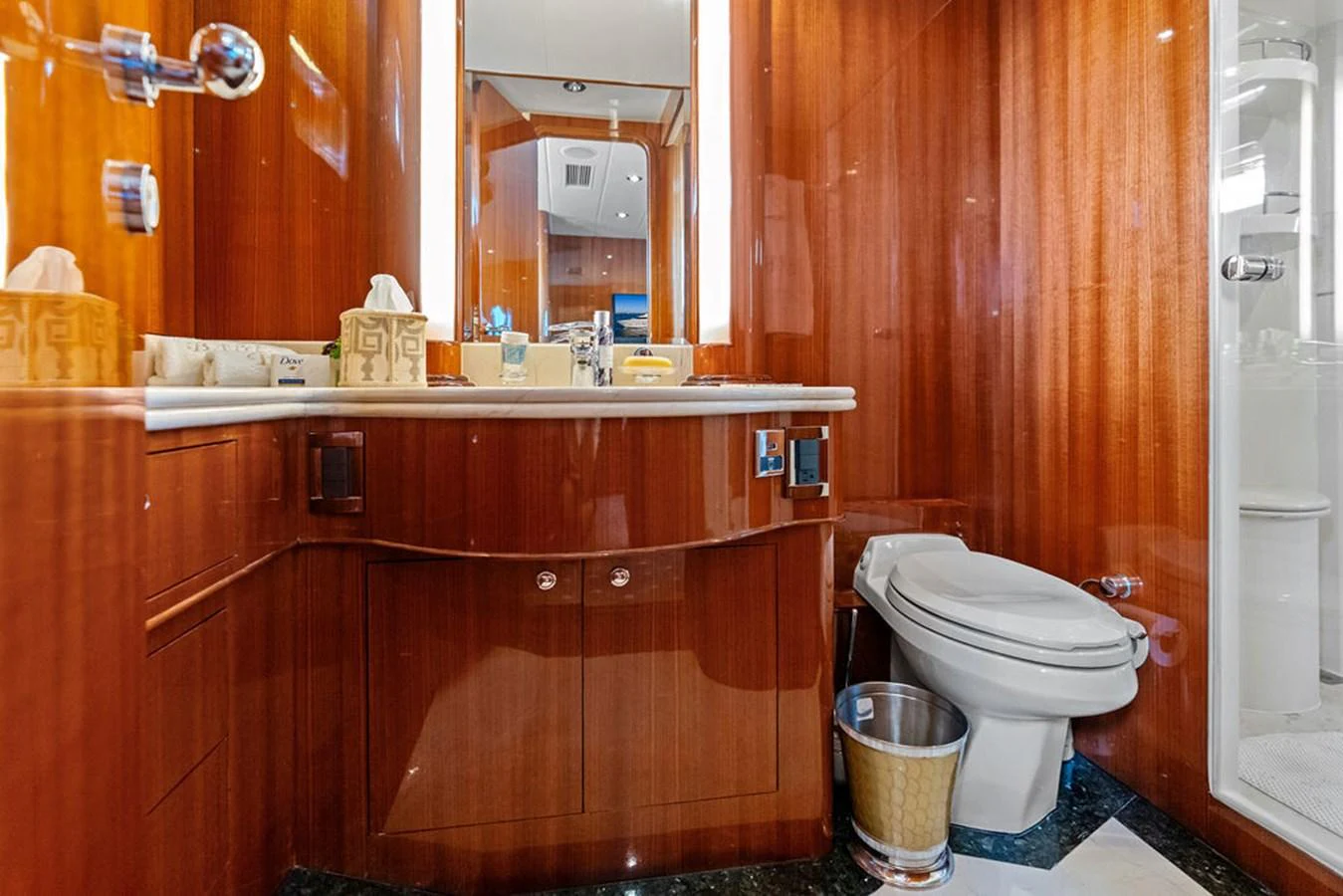 The bathroom features elegant wood paneling and modern fixtures. aboard BABE Yacht for Sale
