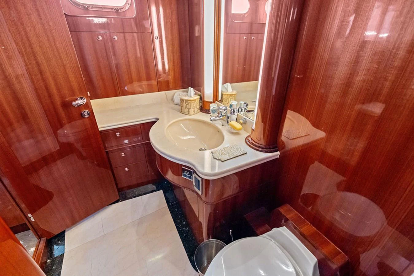The yacht's bathroom features elegant wood paneling and modern fixtures. aboard BABE Yacht for Sale