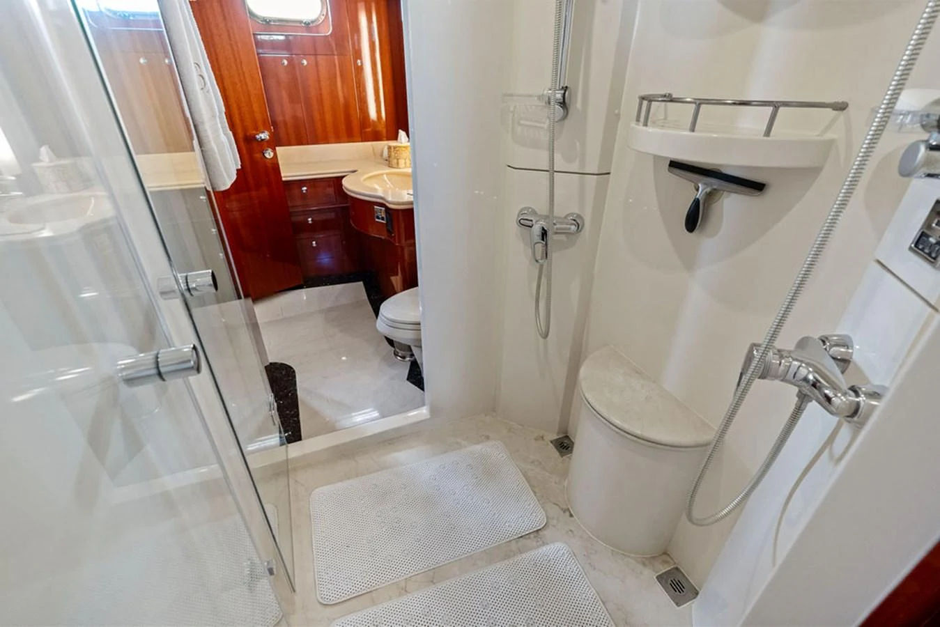The yacht's bathroom features a modern shower area with sleek fixtures and a wooden vanity. aboard BABE Yacht for Sale