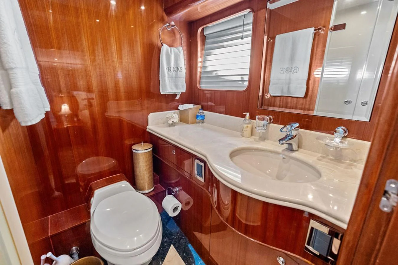 The yacht's bathroom features elegant wood paneling and modern fixtures. aboard BABE Yacht for Sale