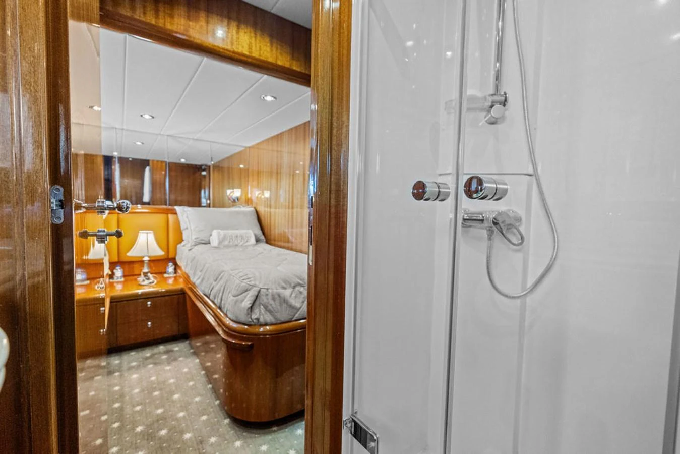 A cozy stateroom with a comfortable bed and adjacent shower area. aboard BABE Yacht for Sale
