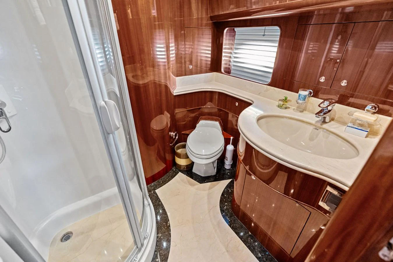 The yacht's bathroom features elegant wood finishes and a spacious shower. aboard BABE Yacht for Sale