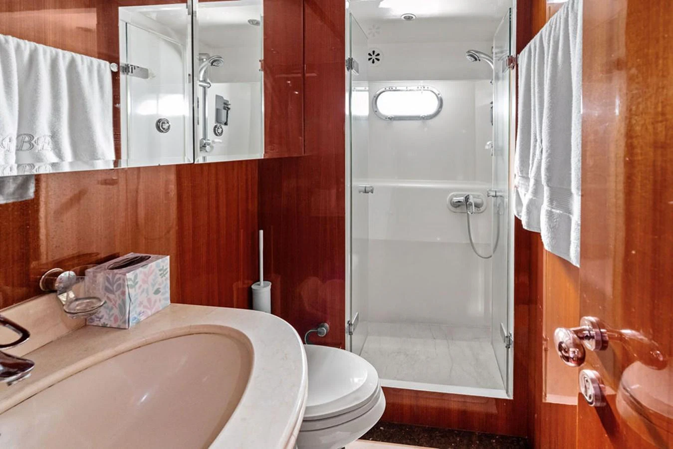 The yacht's bathroom features a sleek design with a shower, sink, and mirrored cabinets. aboard BABE Yacht for Sale