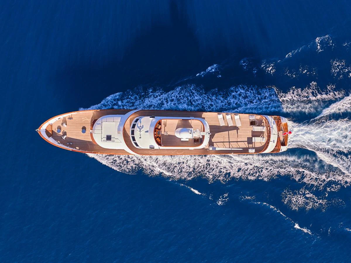 A stunning aerial view of a luxurious yacht cruising through the deep blue sea. aboard RESINA Yacht for Sale