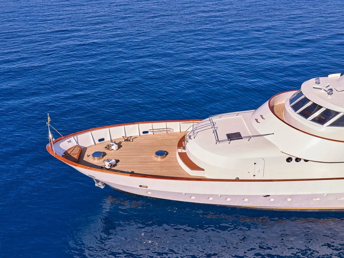 The yacht's bow gracefully cuts through the serene blue waters, showcasing its elegant design and spacious deck. aboard RESINA Yacht for Sale