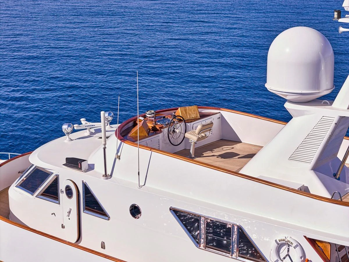 The yacht's flybridge offers a serene and elevated view over the calm blue sea. aboard RESINA Yacht for Sale