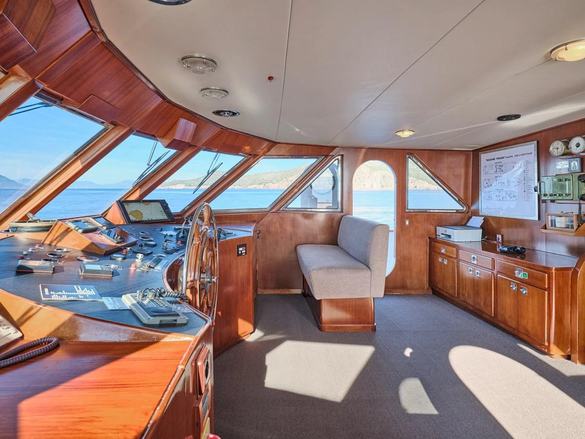 The helm station features a panoramic view with wooden accents and modern navigation equipment. aboard RESINA Yacht for Sale