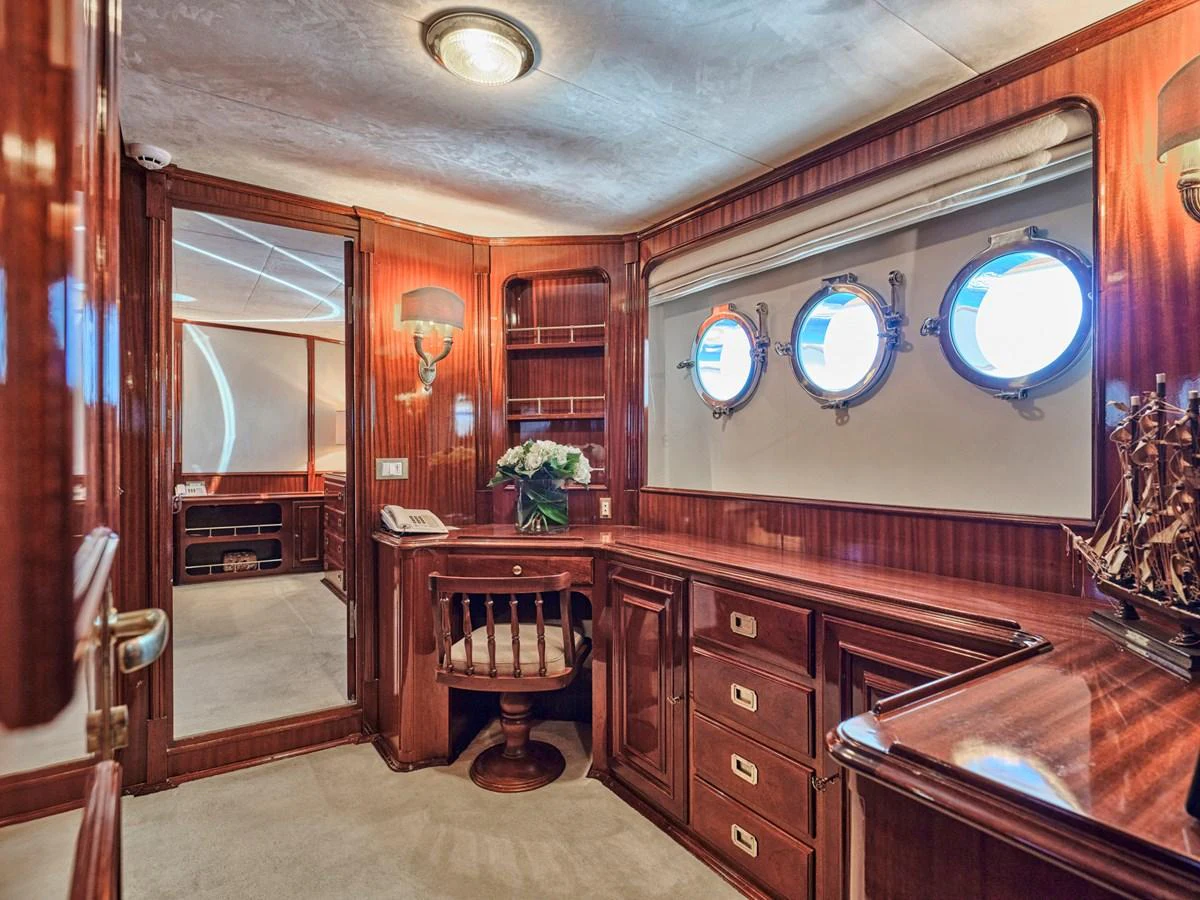 The yacht's office features rich wood paneling, porthole windows, and elegant furnishings. aboard RESINA Yacht for Sale