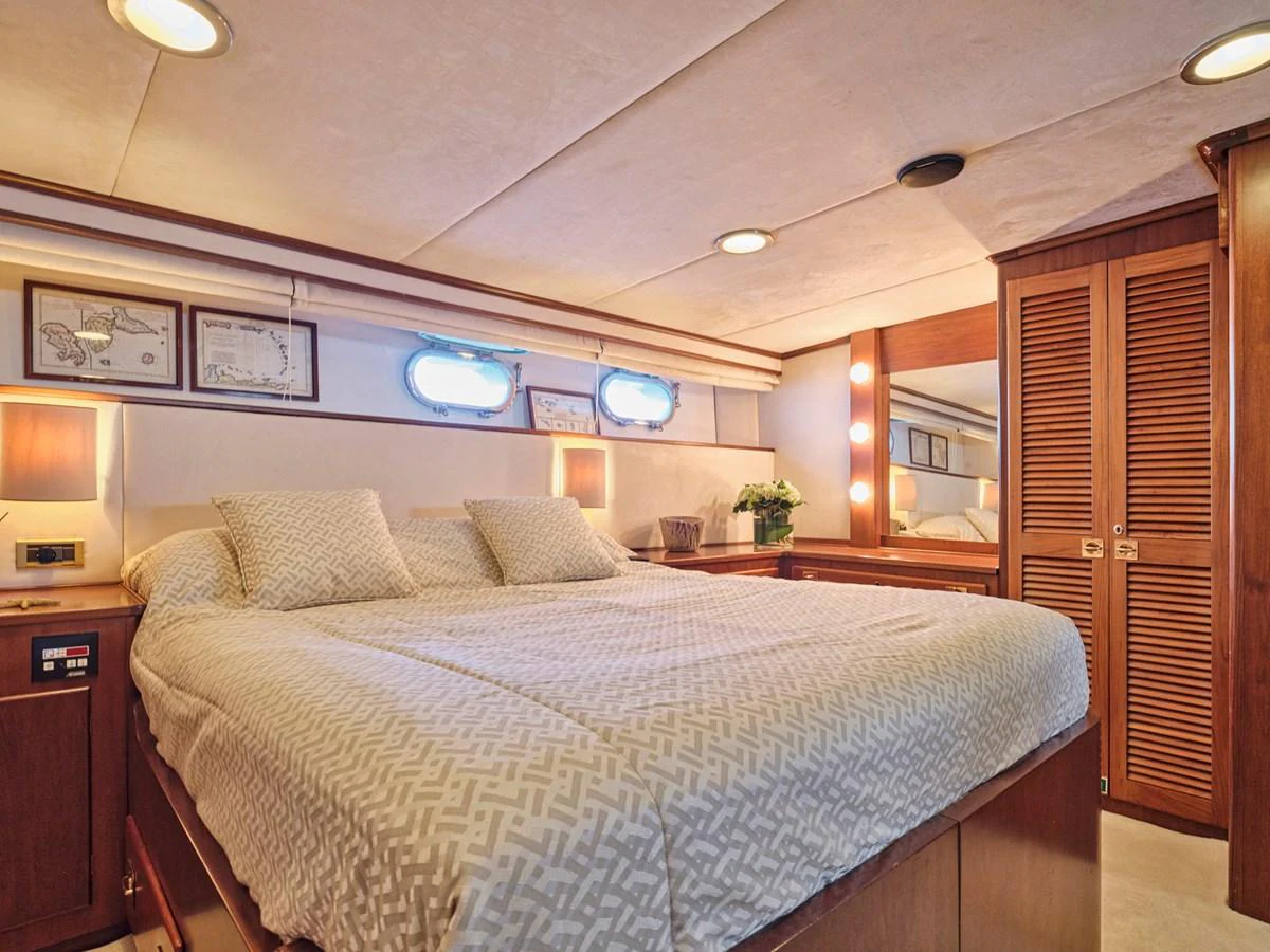 The master stateroom features a spacious bed with elegant bedding and ample storage. aboard RESINA Yacht for Sale