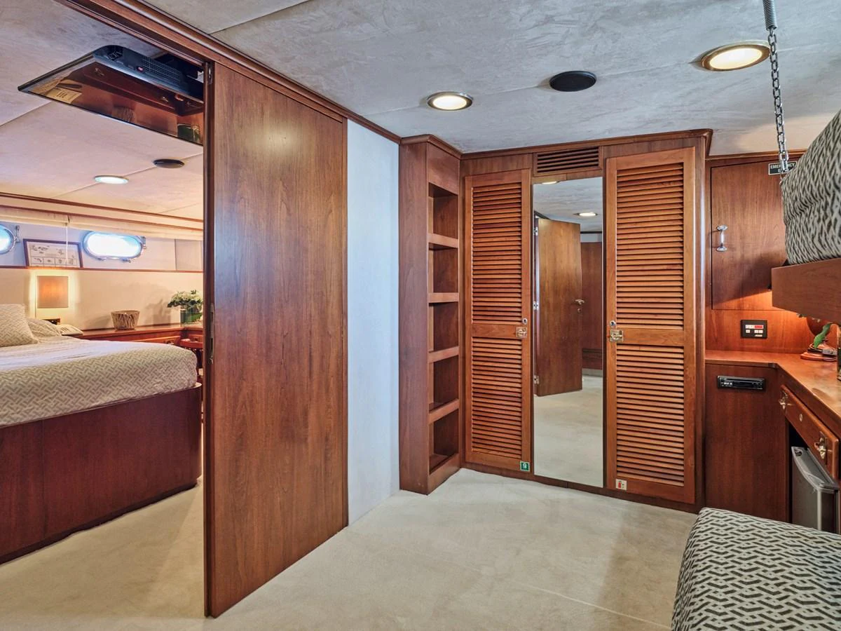 The yacht's stateroom features warm wood finishes and ample storage space. aboard RESINA Yacht for Sale