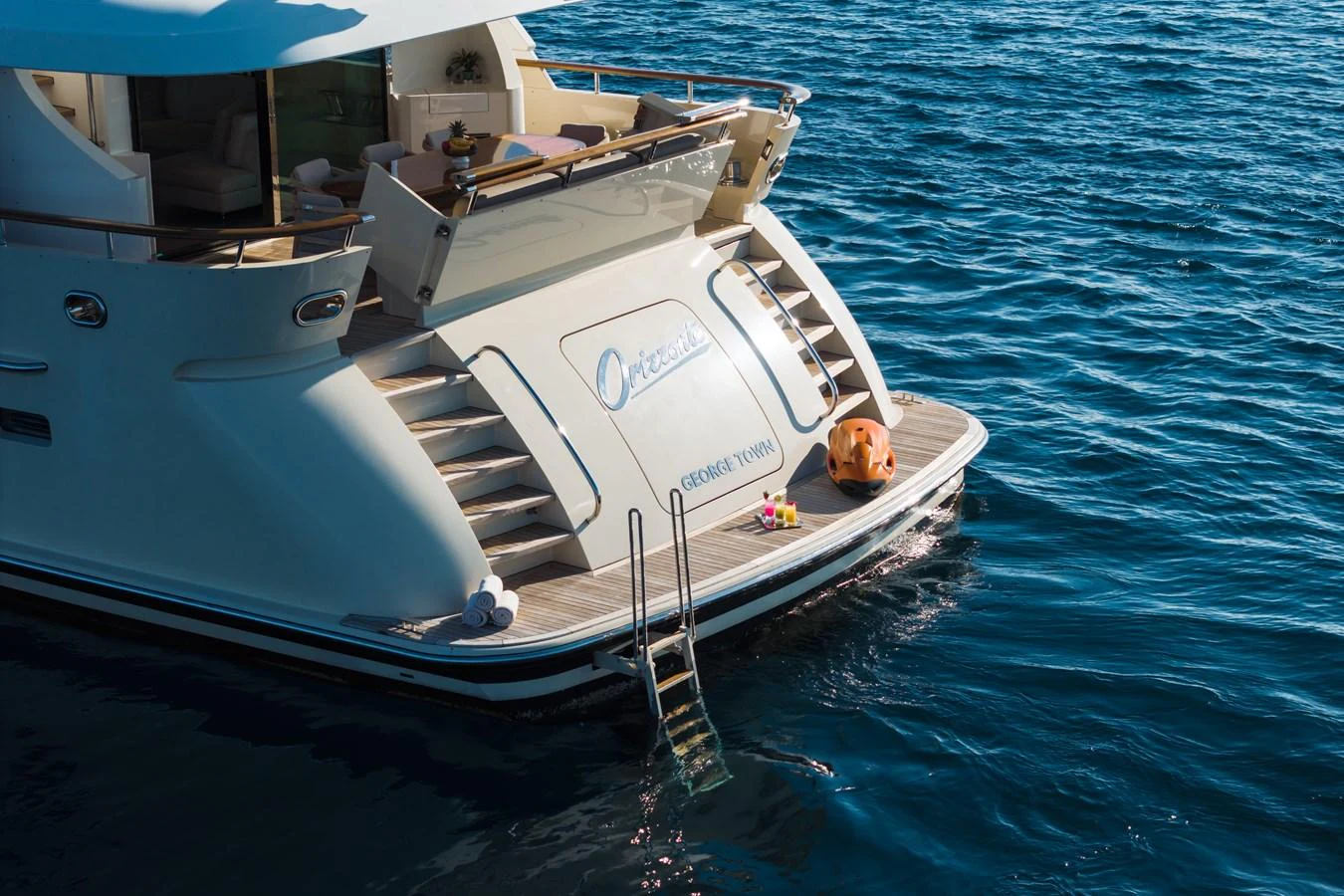 The yacht's aft deck features a swim platform with easy access to the water. aboard ORIZZONTE Yacht for Sale