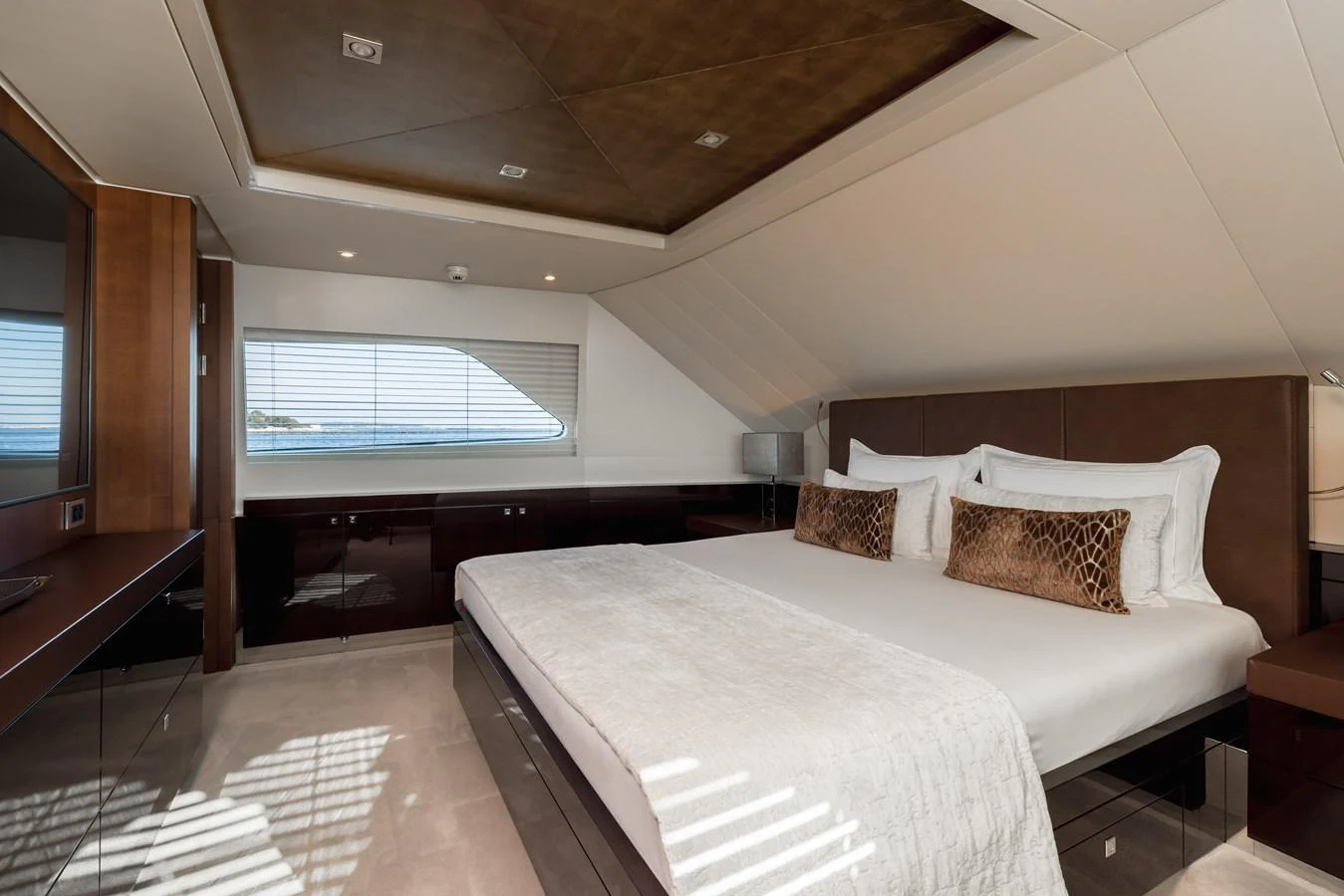 The master stateroom features a spacious bed with elegant decor and a large window offering a scenic view. aboard ORIZZONTE Yacht for Sale
