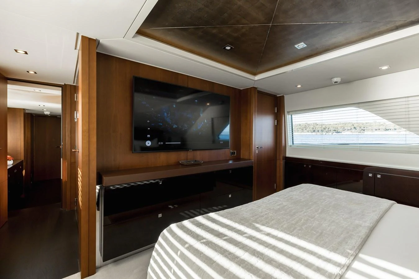 The stateroom features a sleek, modern design with a large flat-screen TV and ample natural light. aboard ORIZZONTE Yacht for Sale