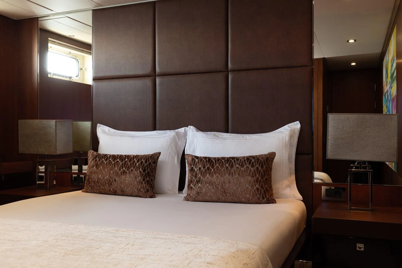 The stateroom features a luxurious bed with plush pillows and elegant lighting. aboard ORIZZONTE Yacht for Sale