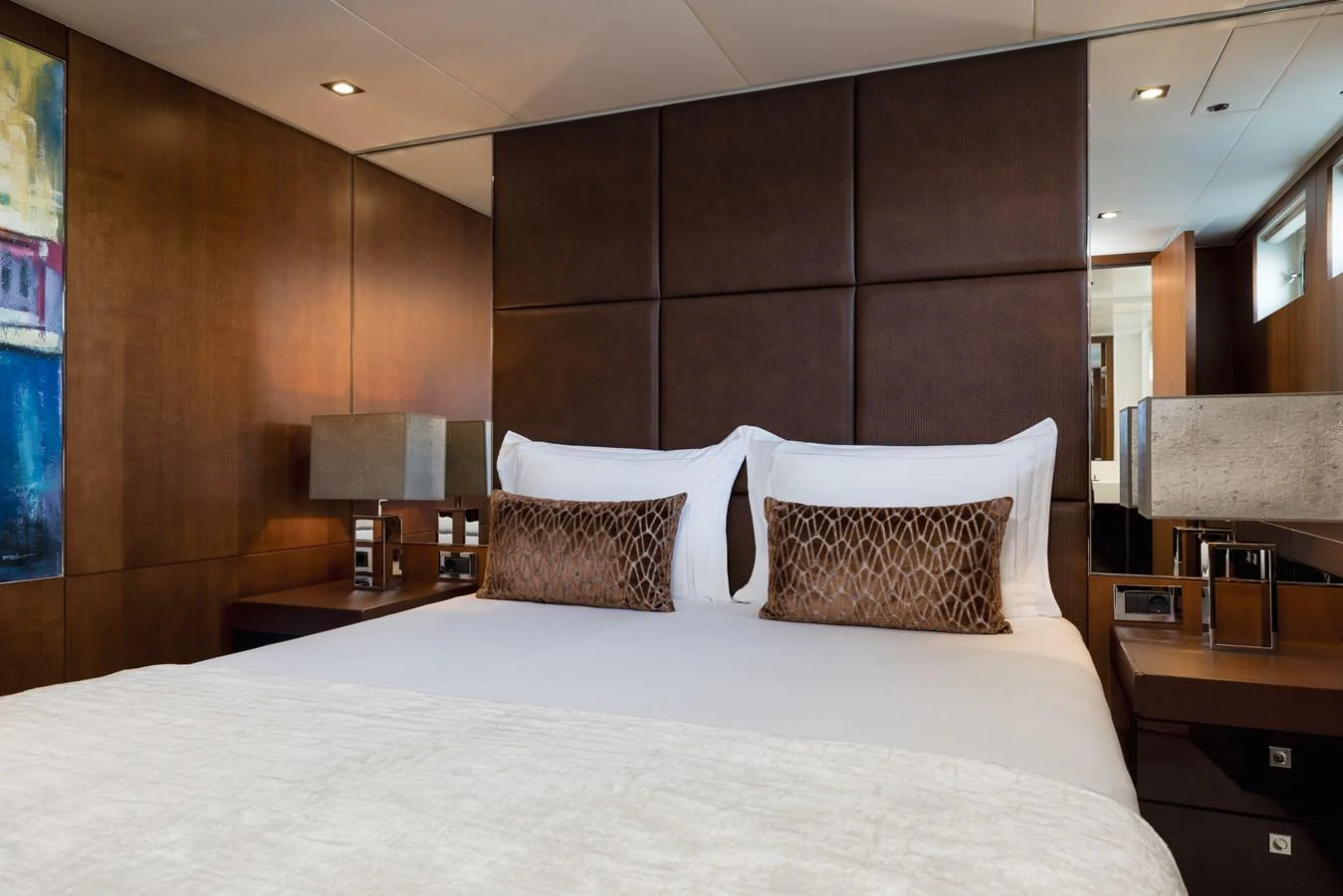 The stateroom features a luxurious bed with elegant decor and modern lighting. aboard ORIZZONTE Yacht for Sale