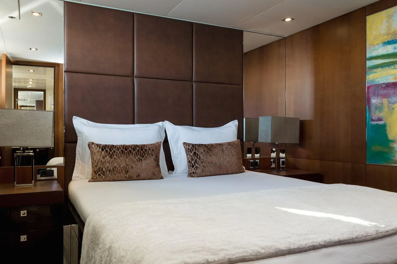 The stateroom features a plush bed with elegant decor and modern lighting. aboard ORIZZONTE Yacht for Sale