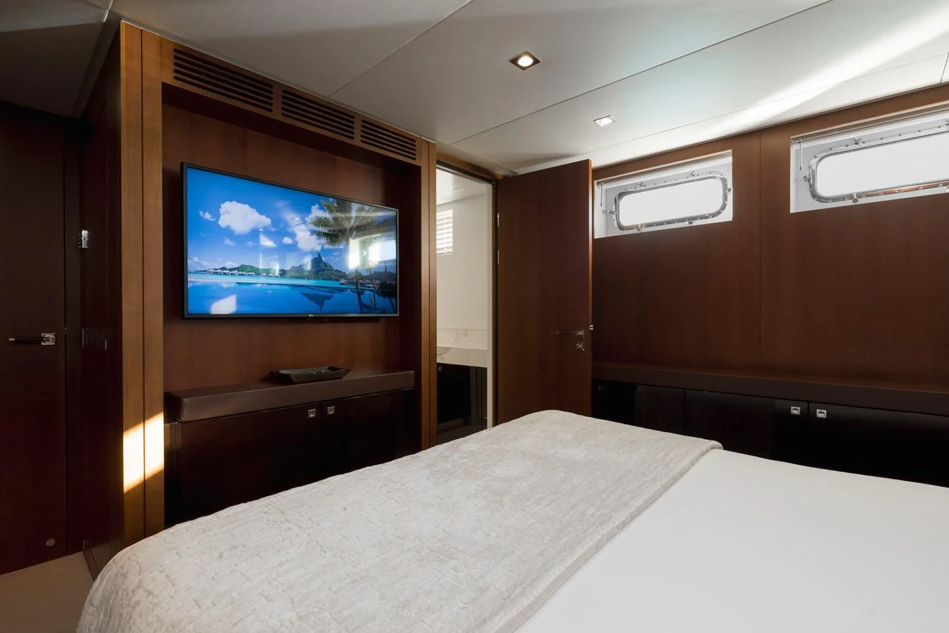 The stateroom features a comfortable bed and a large flat-screen TV, creating a cozy and luxurious atmosphere. aboard ORIZZONTE Yacht for Sale