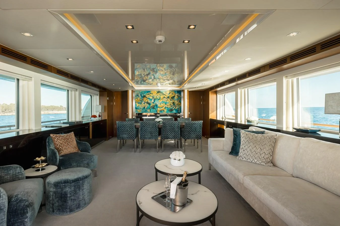 The yacht's salon features luxurious seating, elegant decor, and expansive windows offering stunning ocean views. aboard ORIZZONTE Yacht for Sale