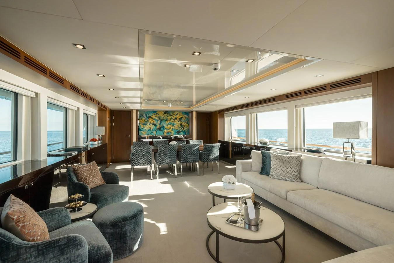 The yacht's salon features plush seating, a dining area, and large windows offering panoramic ocean views. aboard ORIZZONTE Yacht for Sale