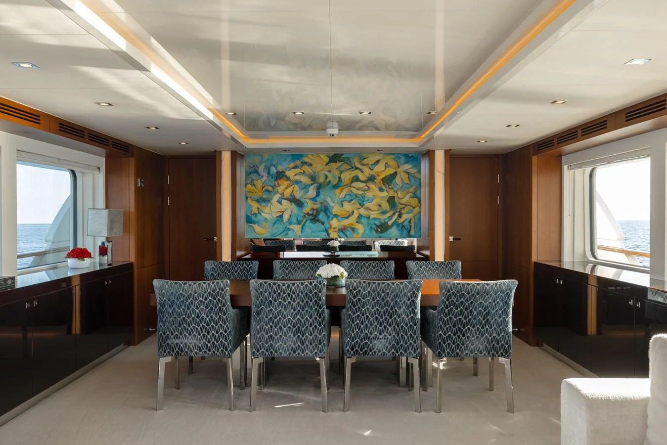 The yacht's dining area features elegant seating and a vibrant wall mural, creating a sophisticated ambiance. aboard ORIZZONTE Yacht for Sale