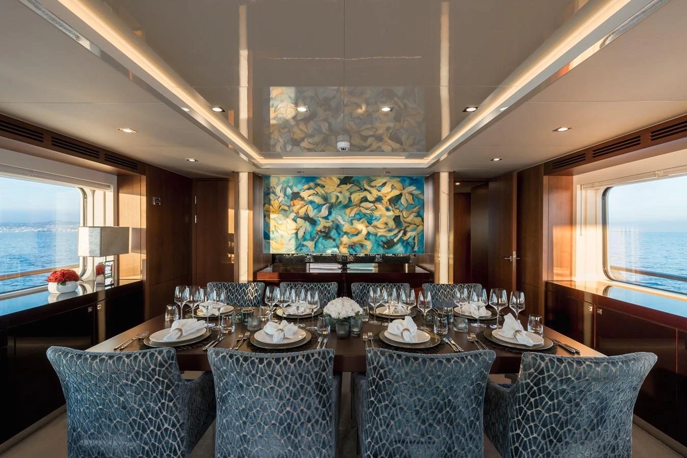 The yacht's dining area features elegant seating and a stunning ocean view. aboard ORIZZONTE Yacht for Sale