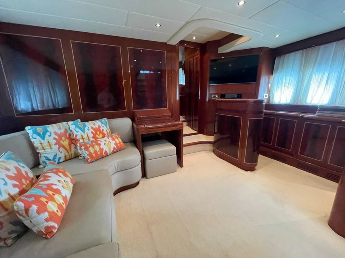 The yacht's interior features a cozy seating area with vibrant cushions and elegant wood paneling. aboard MANGUSTA 72 Yacht for Sale