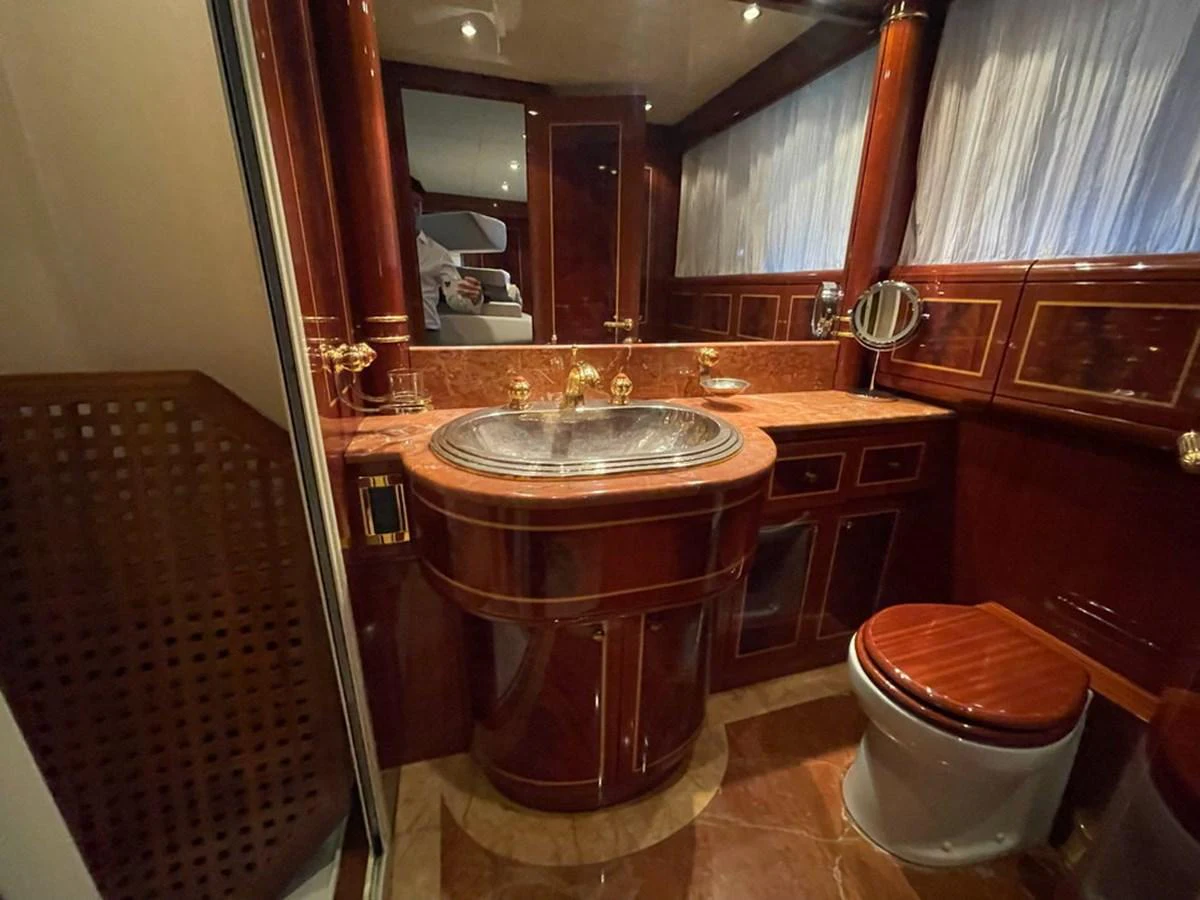 The yacht's bathroom features luxurious wood finishes and elegant fixtures. aboard MANGUSTA 72 Yacht for Sale