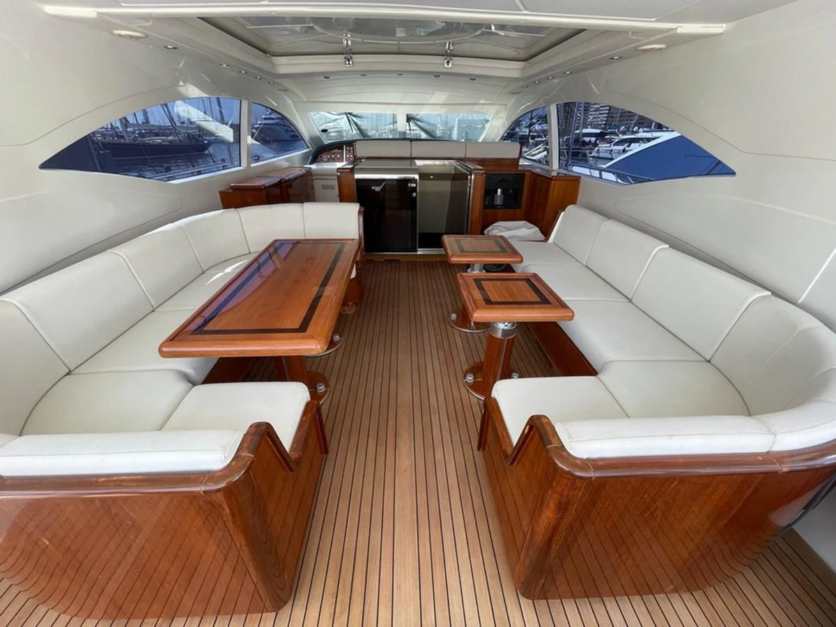 The yacht's saloon features elegant wood finishes and comfortable seating, perfect for socializing and relaxation. aboard MANGUSTA 72 Yacht for Sale