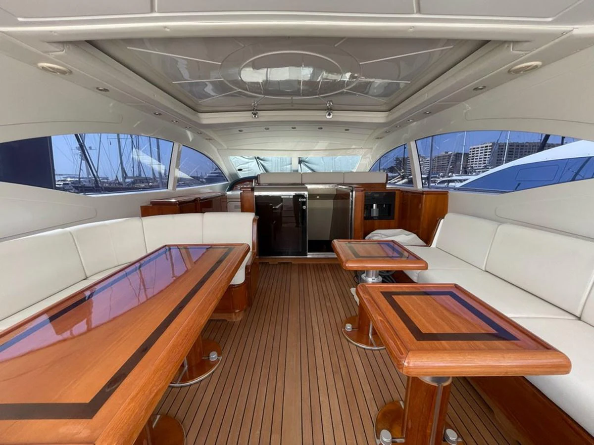 The yacht's saloon features elegant wooden tables and plush seating, creating a refined and comfortable atmosphere. aboard MANGUSTA 72 Yacht for Sale