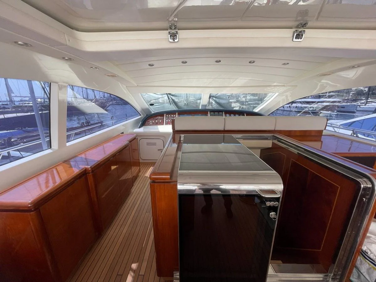 The yacht's helm area features a sleek design with polished wood finishes and modern navigation equipment. aboard MANGUSTA 72 Yacht for Sale