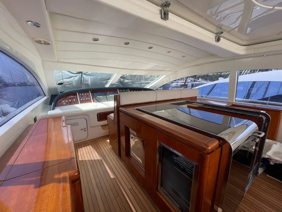 The helm area features elegant wood finishes and modern navigation equipment. aboard MANGUSTA 72 Yacht for Sale