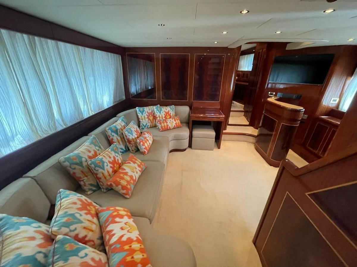 The salon features a comfortable seating area with vibrant cushions and elegant wooden finishes. aboard MANGUSTA 72 Yacht for Sale