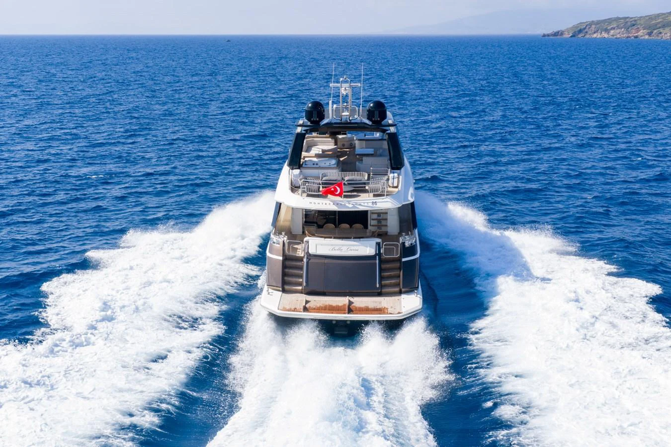 A luxurious yacht cruises through the open sea, leaving a trail of white waves behind. aboard BELLA LUNA Yacht for Sale
