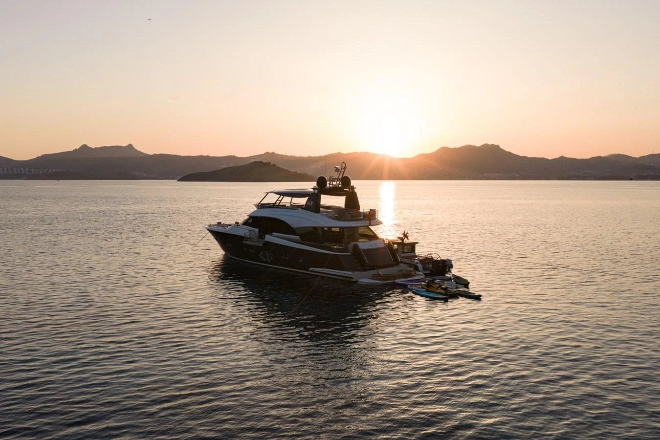 A luxurious yacht is anchored at sunset, creating a serene and picturesque scene on the water. aboard BELLA LUNA Yacht for Sale