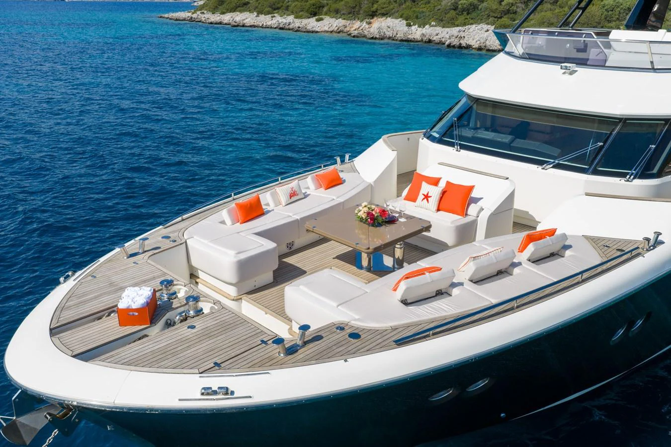 The yacht's foredeck features luxurious sun pads and seating with vibrant orange accents, perfect for relaxation. aboard BELLA LUNA Yacht for Sale