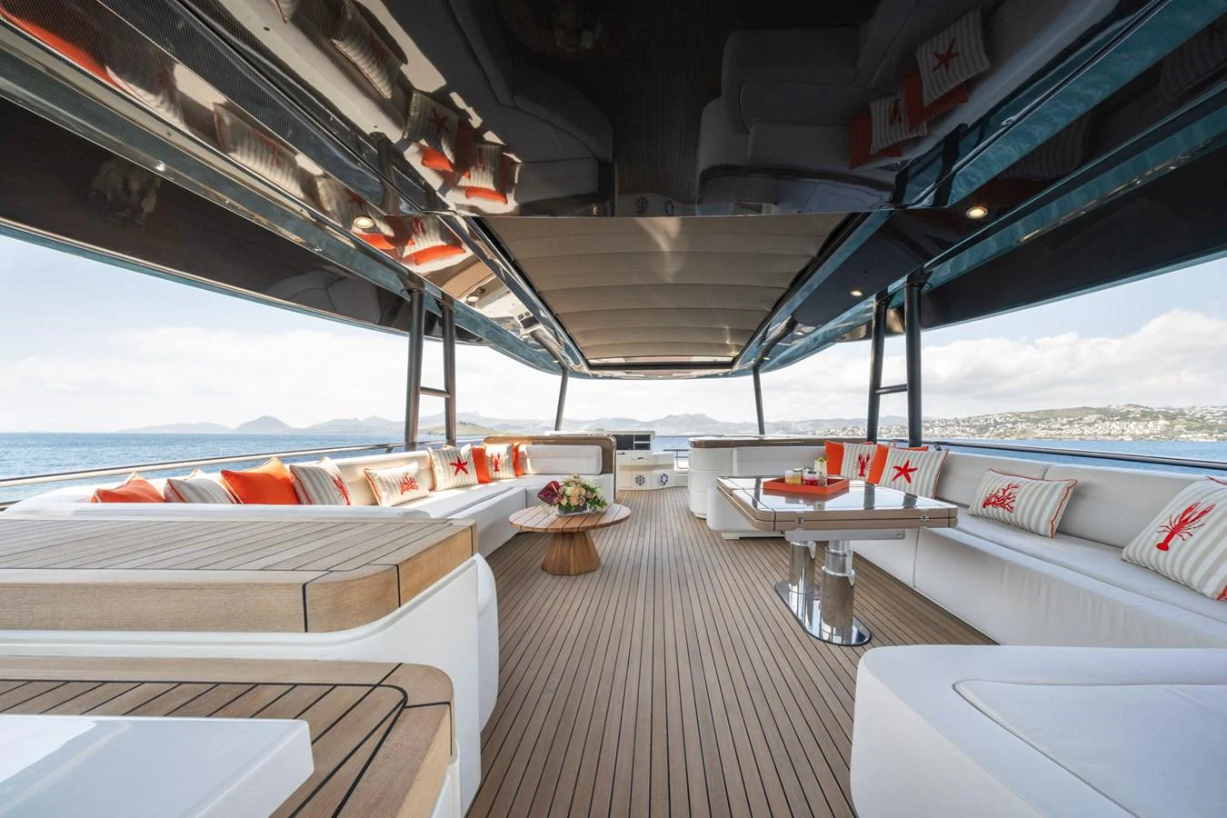 The sundeck features spacious seating with elegant wooden accents and vibrant cushions, offering a luxurious outdoor lounging experience. aboard BELLA LUNA Yacht for Sale
