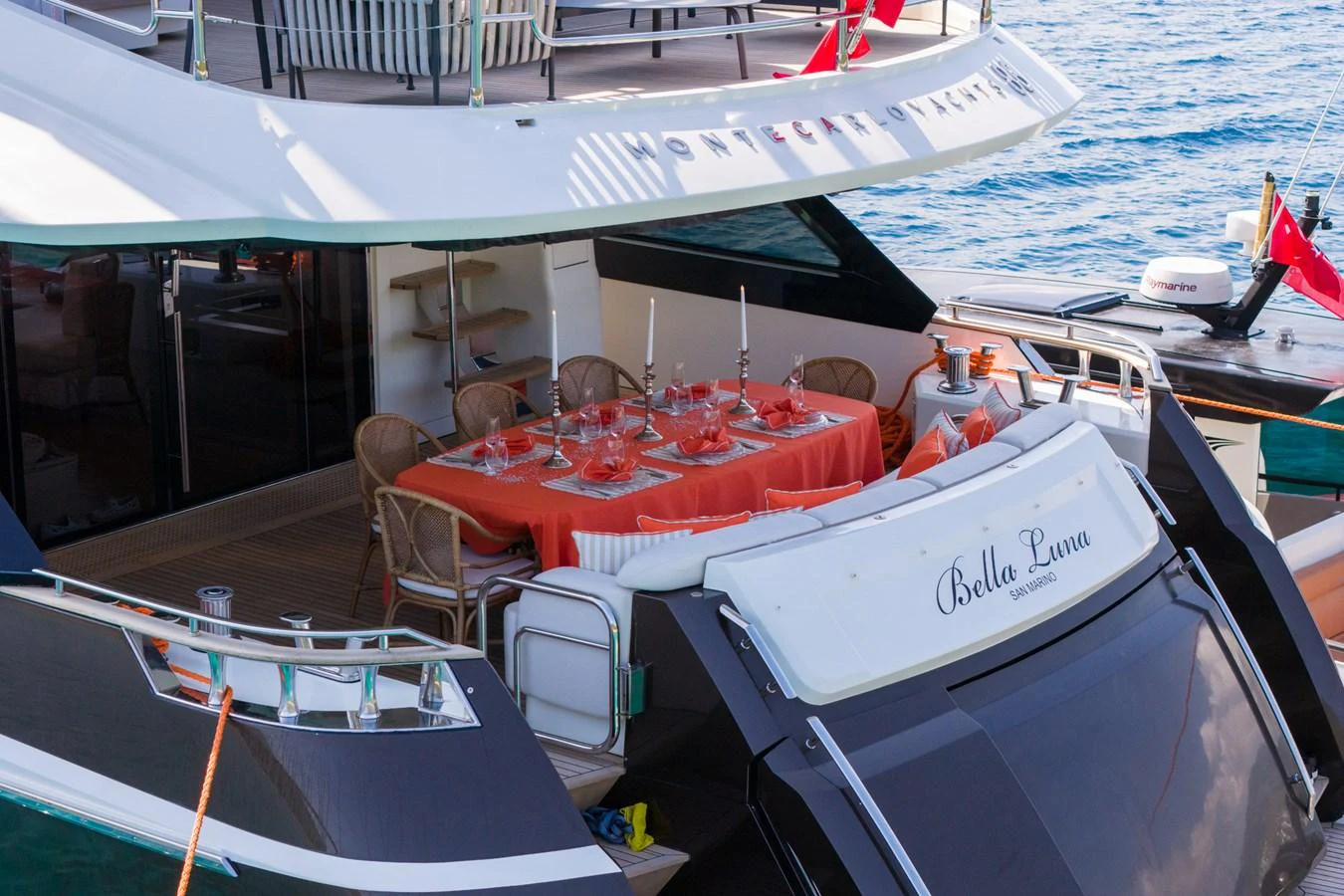 The aft deck features an elegant dining setup with a view of the water. aboard BELLA LUNA Yacht for Sale