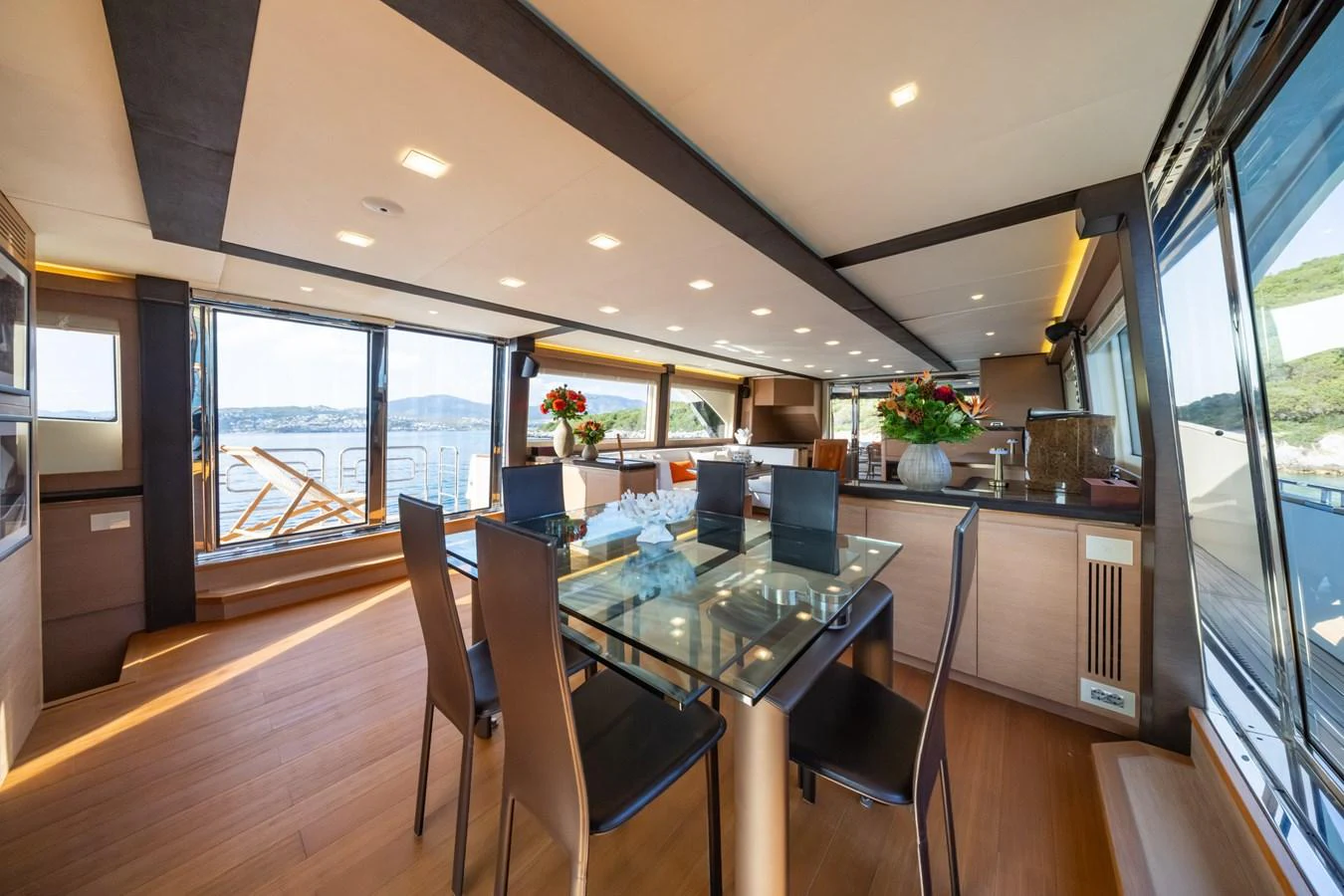 The yacht's dining area features a modern glass table and elegant seating with panoramic views. aboard BELLA LUNA Yacht for Sale