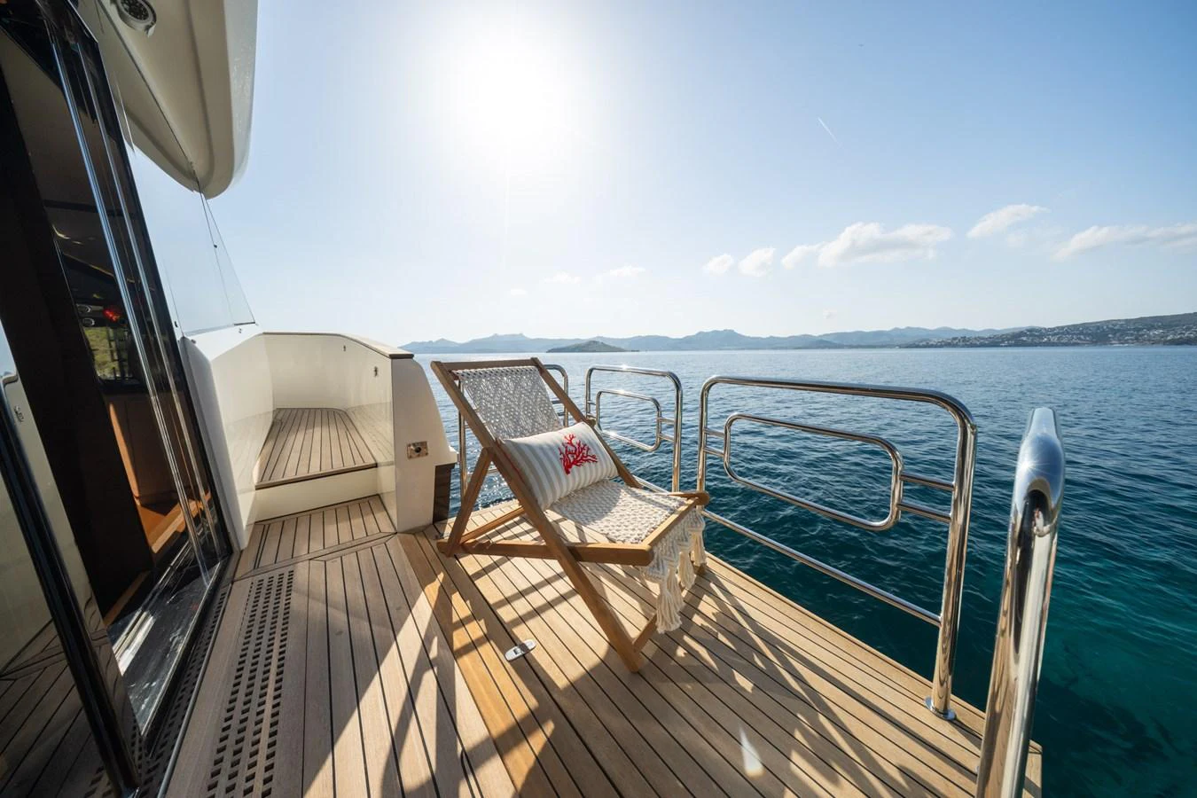 The aft deck features a comfortable lounge chair with a scenic ocean view. aboard BELLA LUNA Yacht for Sale