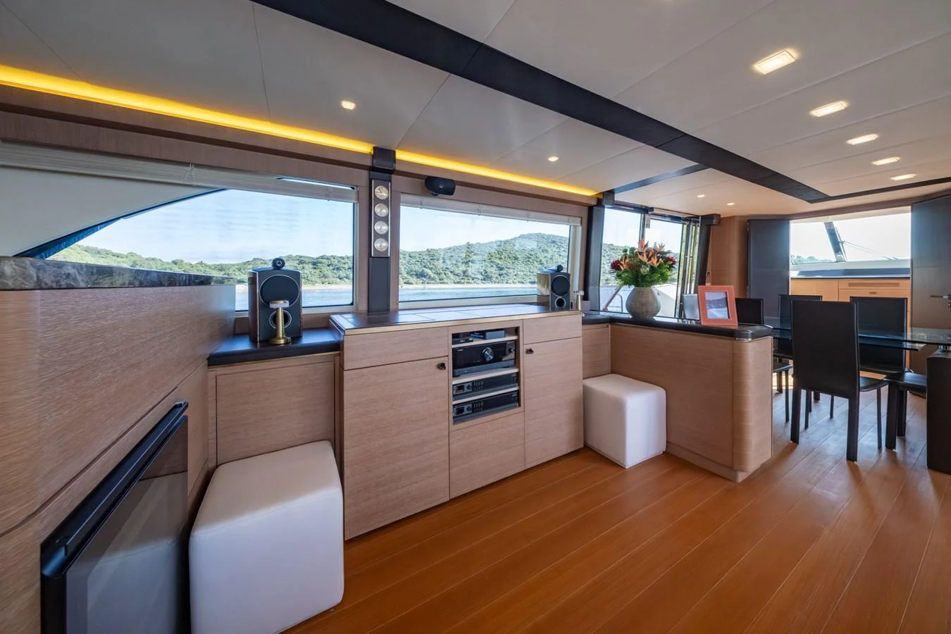 The salon features modern wood finishes, ample seating, and large windows for natural light. aboard BELLA LUNA Yacht for Sale