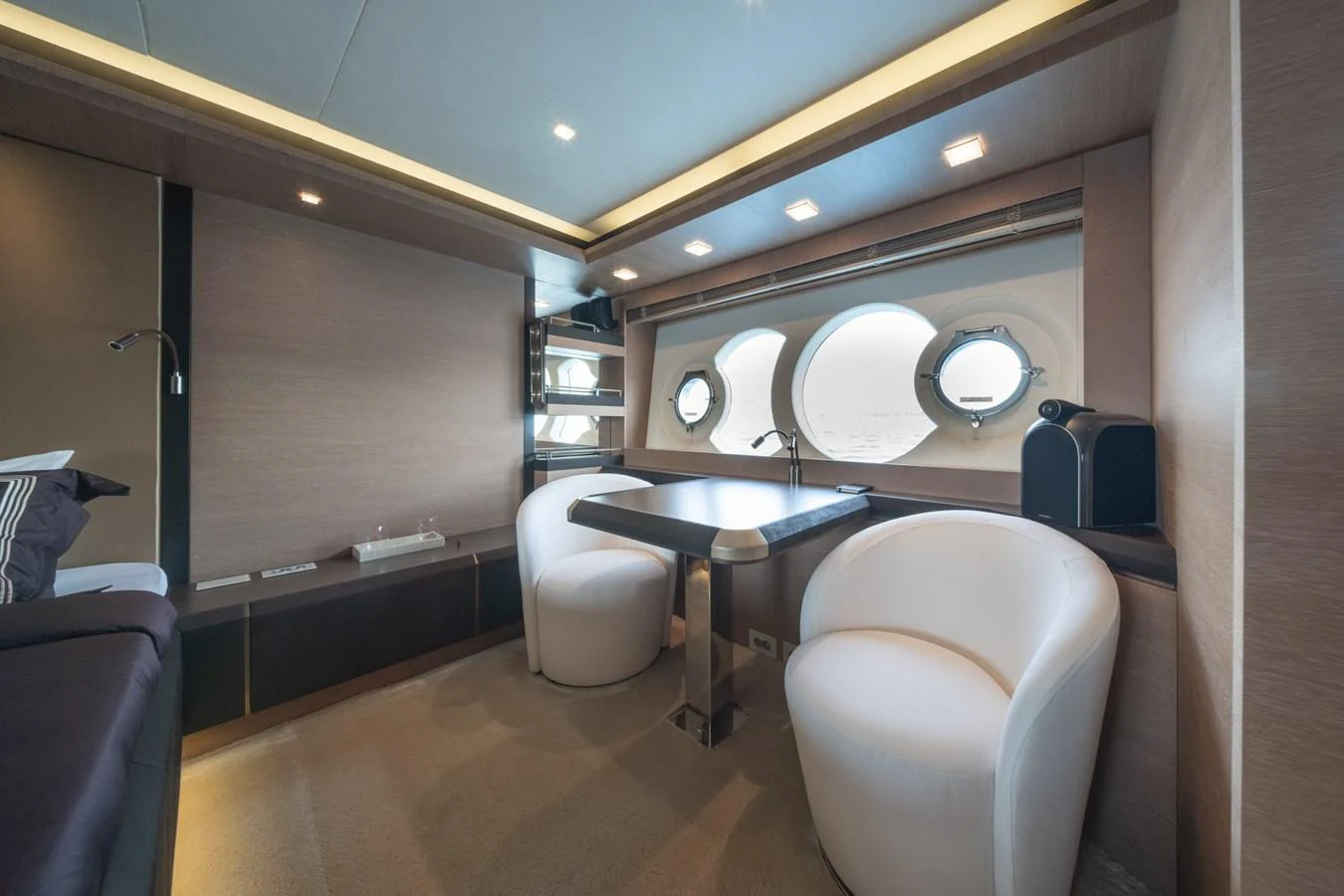 The yacht's interior features a cozy seating area with modern furnishings and circular windows. aboard BELLA LUNA Yacht for Sale