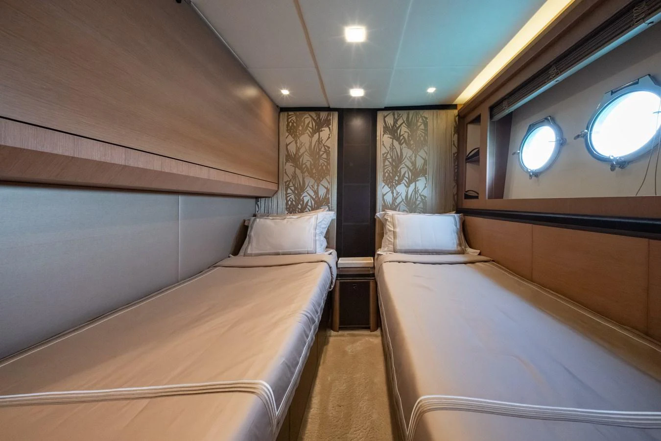 The twin stateroom features two comfortable beds with elegant bedding and ample natural light from the portholes. aboard BELLA LUNA Yacht for Sale