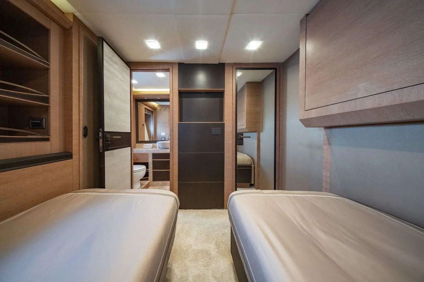 The guest stateroom features twin beds and a modern, minimalist design with ample storage and soft lighting. aboard BELLA LUNA Yacht for Sale