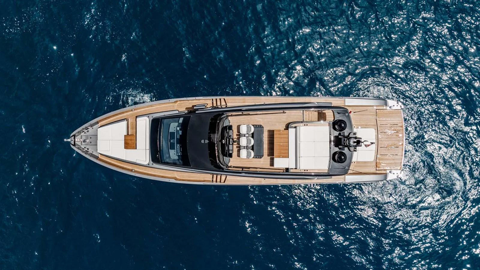 Aerial view of a sleek, modern yacht cruising through deep blue waters. aboard REEMA Yacht for Sale