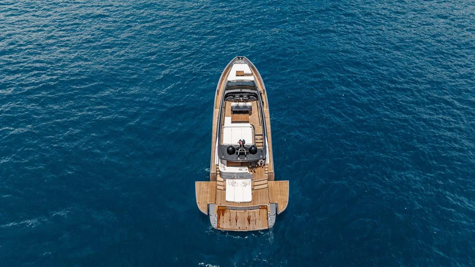 A sleek yacht cruises through the open sea, showcasing its elegant design from an aerial perspective. aboard REEMA Yacht for Sale